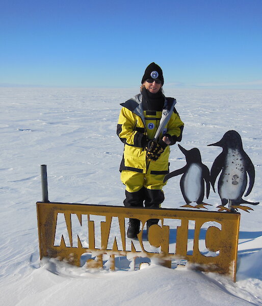 Gwen beside the Antarctic Circle sign.