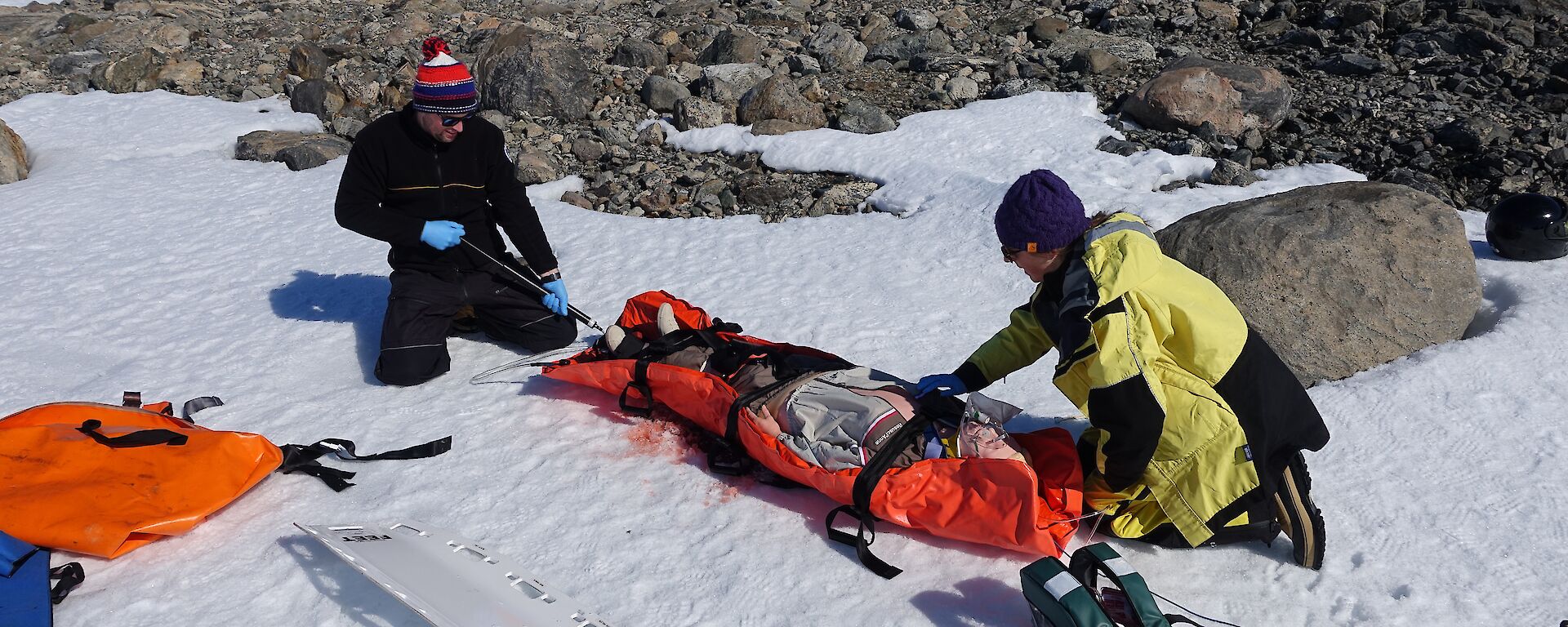 John Cherry (left) and Jessie Ling secure a patient for transport during scenario training at Casey station.