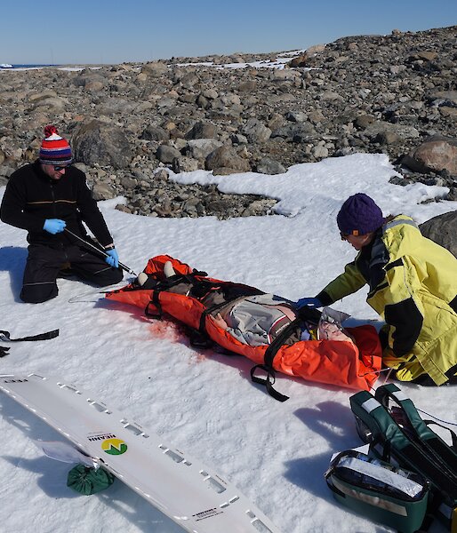 John Cherry (left) and Jessie Ling secure a patient for transport during scenario training at Casey station.