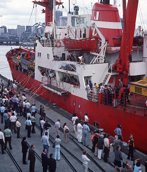 The Nella Dan tied up beside the wharf in Hobart as people throw streamers in farewell.