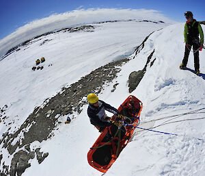 Expeditioners learn search and rescue and technical rope rescue techniques from a field training officer in Antarctica.