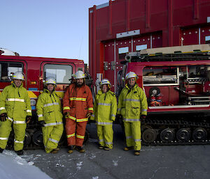 Five members of the Mawson station fire team beside their fire Hägglunds.