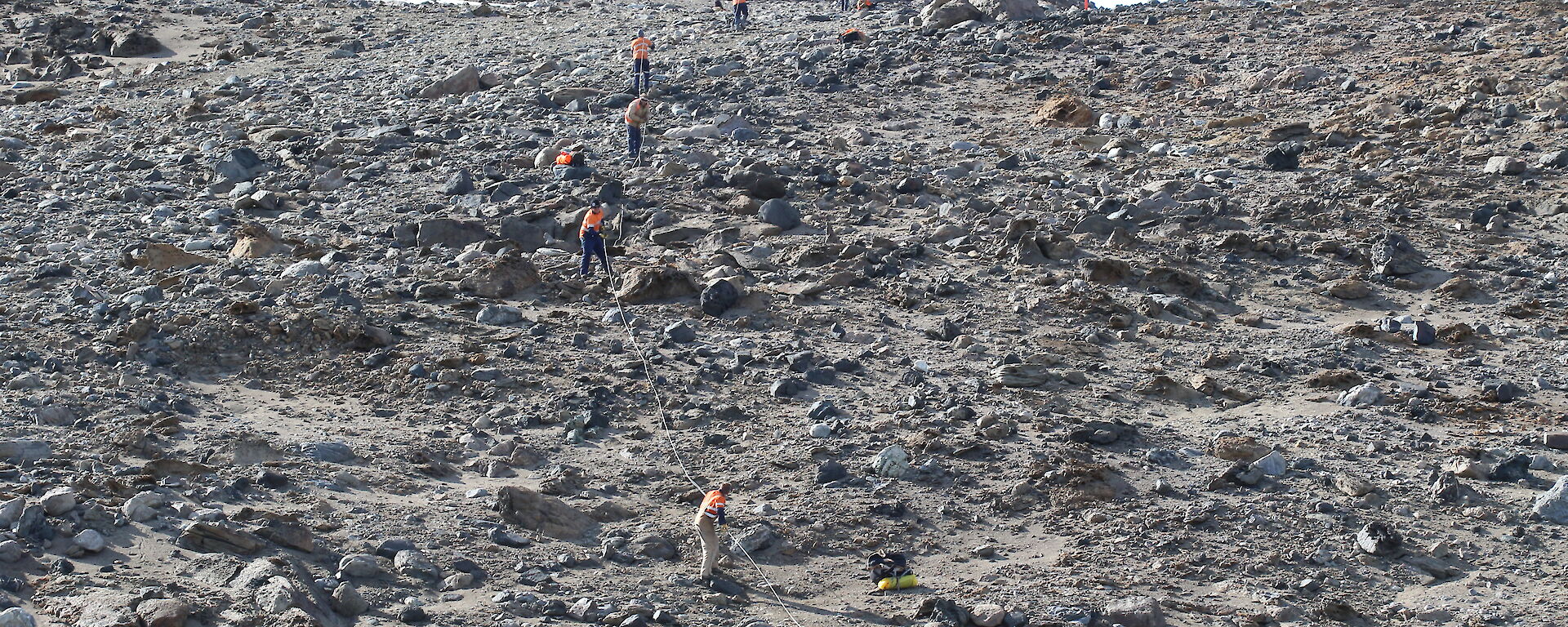 Expeditioners hauling one of the power cables up a steep section of the Vestfold Hills.