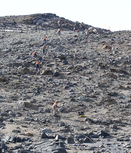 Expeditioners hauling one of the power cables up a steep section of the Vestfold Hills.