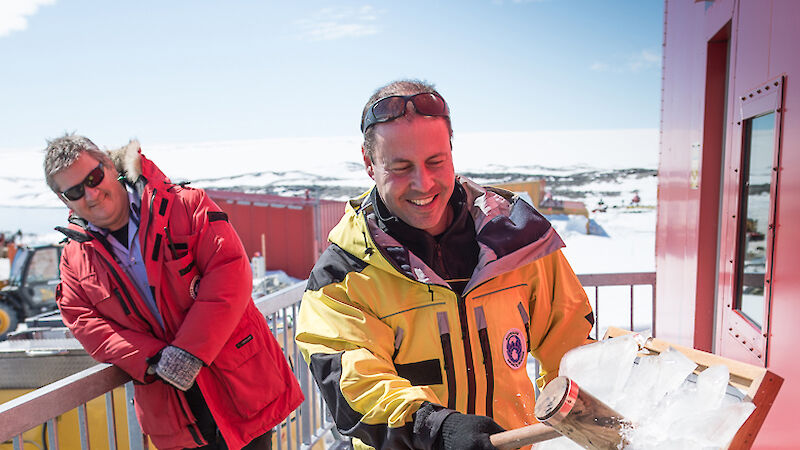 Minister for the Environment and Energy, the Hon. Josh Frydenberg MP, smashes ice from a plaque with a small wooden hammer.