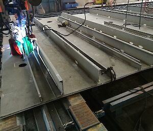 Structural steel bars or stiffeners being welded on to plate steel.