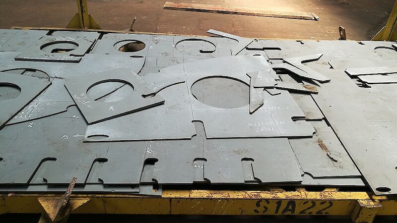 Steel plate cut into parts using laser and plasma technology and high pressure water.
