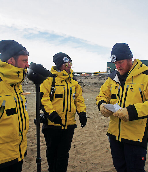 Phil Harper (left) and Briege Whitehead (centre) talk about station activities with Station Leader Robb Clifton, prior to filming. Wilson (wearing a protective lens sleeve) looks on.