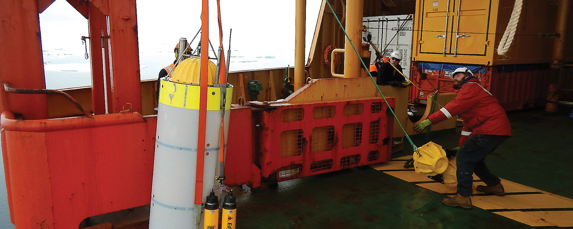 The crew of the Aurora Australis retrieve a moored acoustic recorder from the Southern Ocean.