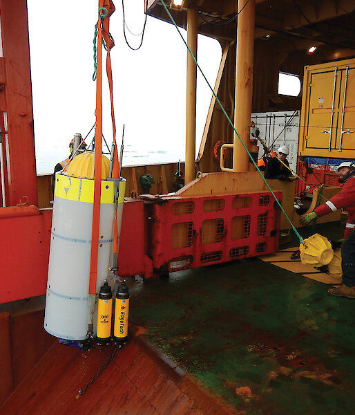 The crew of the Aurora Australis retrieve a moored acoustic recorder from the Southern Ocean.