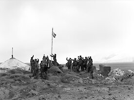 Heard Island expedition leader, Stuart Campbell, raising the Australian flag claiming sovereignty for Australia, and declaring the station at Atlas Cove open.