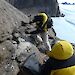 Field biologist, Marcus Salton, chisels a thick sample of very hard mumijo off rocks outside a nest cavity in the Masson Range near Mawson research station.