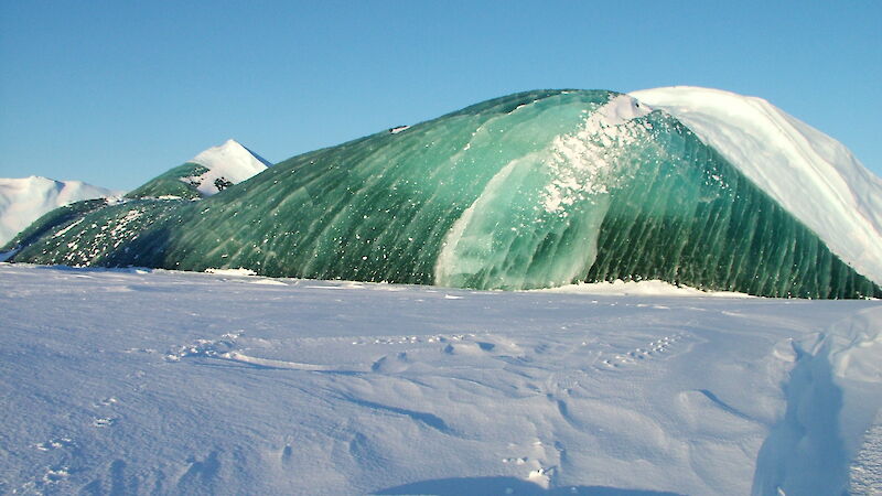 A jade iceberg rising above fast ice.