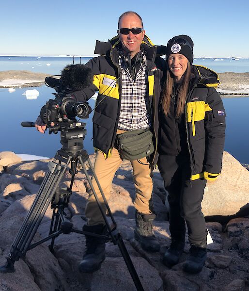 Behind the News team, Peter Curtis and Emma Davis standing on a rock overlooking a bay at Casey.