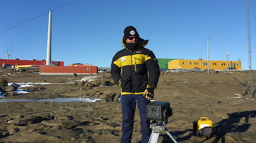 Arts Fellow Martin Walch standing with photographic equipment outside Mawson Station