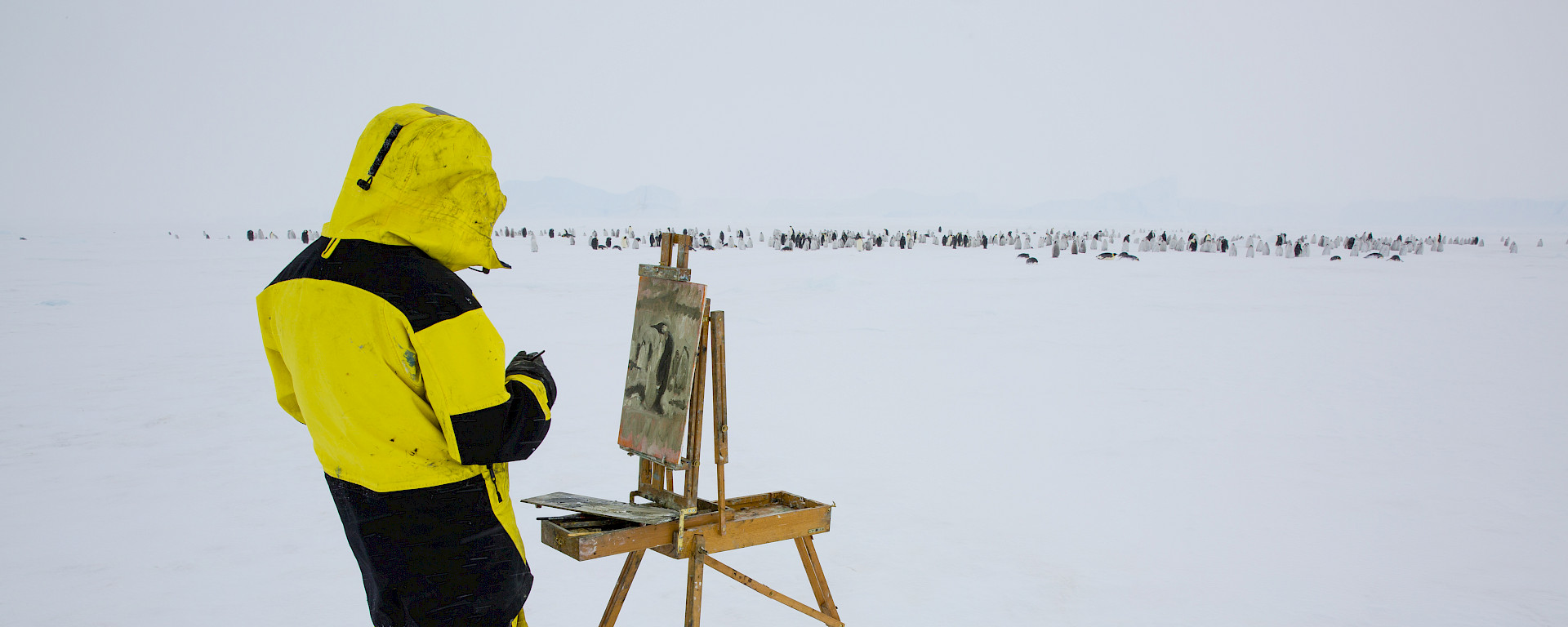 Artist painting on an easel in Antarctica.