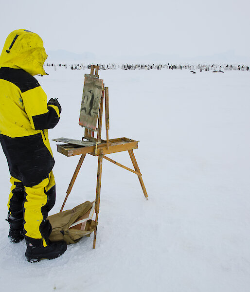 Artist painting on an easel in Antarctica.