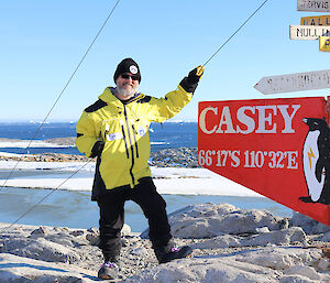 An expeditioner stands next to a sign that says "Casey".