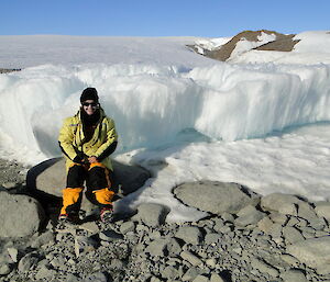 An expeditioner in a rocky and icy landscape.