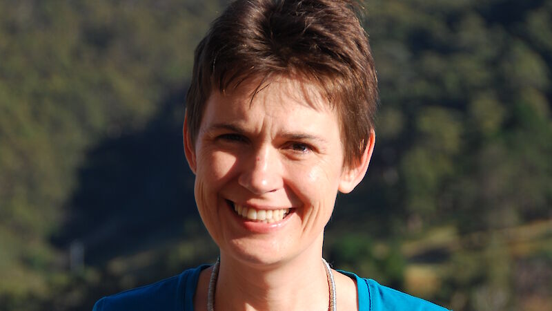 Elizabeth Leane portrait outdoors showing a woman with short hair and forest behind