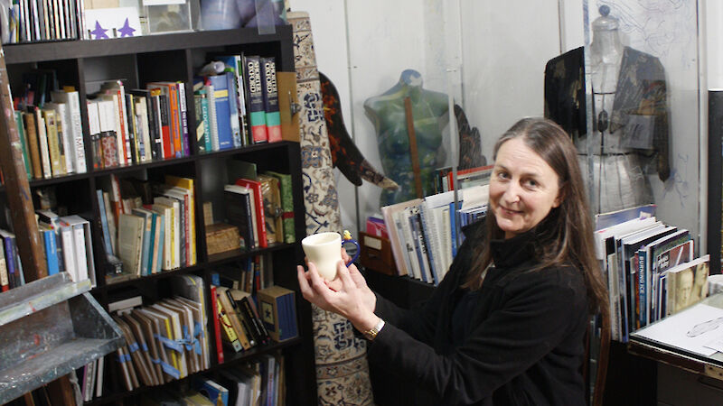 Artist in her studio sitting on stool