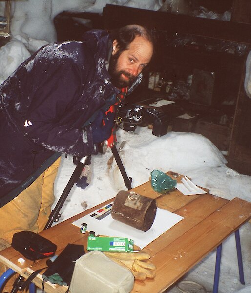 Alasdair McGregor photographing artefacts inside Mawson’s main hut
