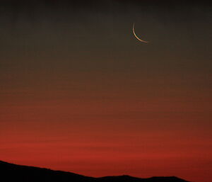 One day old moon with nacreous clouds