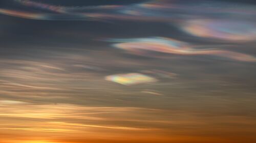 Iridescent clouds above an orange sunset.