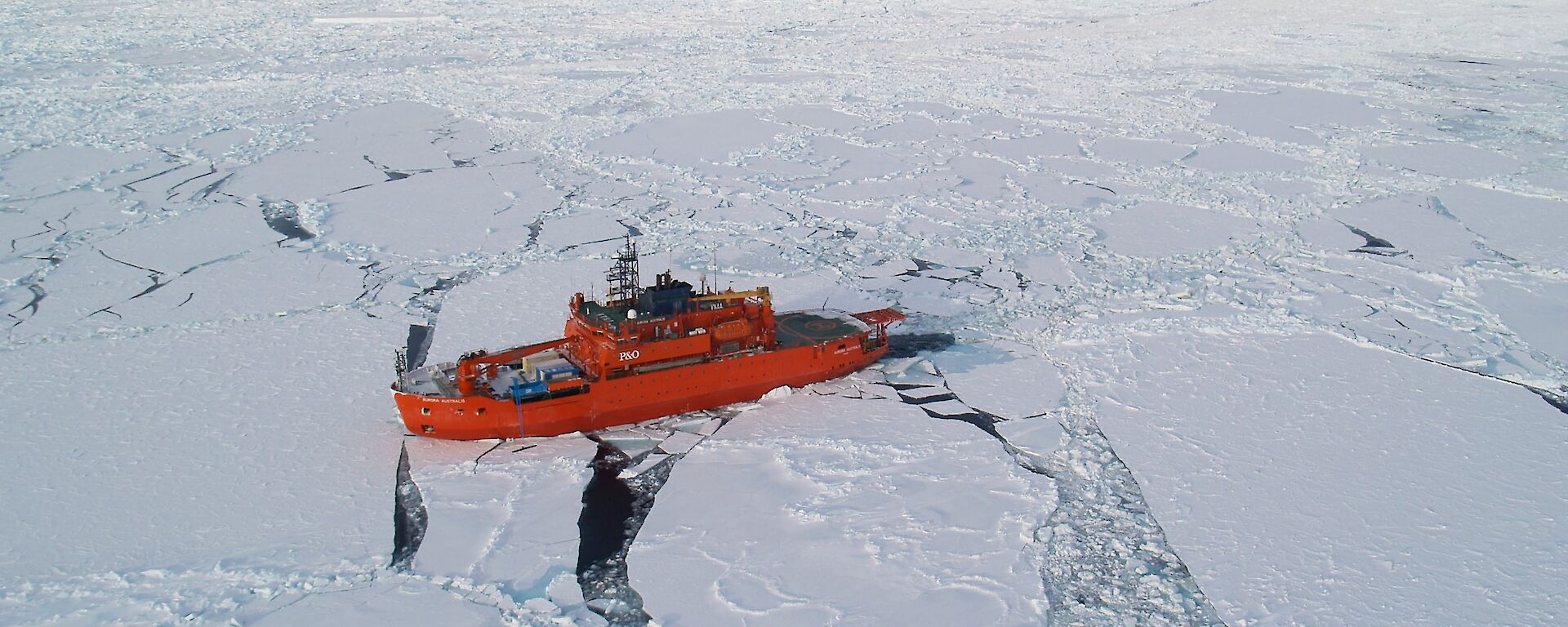 Aerial photo of orange Aurora Australis in pack ice.