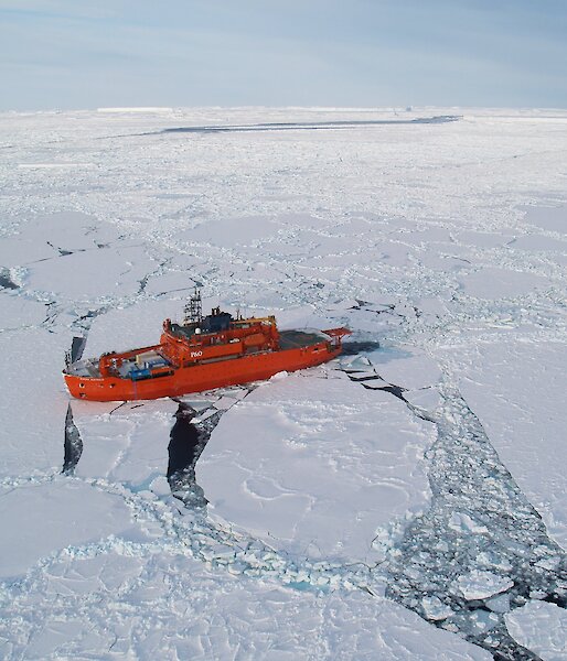 Aerial photo of orange Aurora Australis in pack ice.