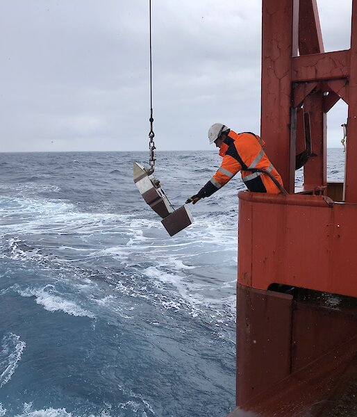 Crew member retrieving the scientific instrument on the ship.