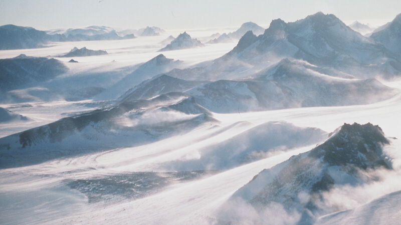 Aerial shot of mountain ranges covered in snow.