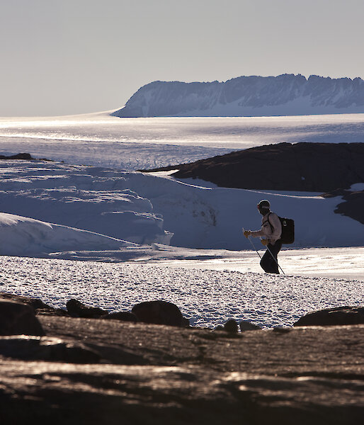 Expeditioner hiking through snow-covered landscape.