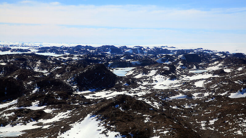 The rocky coastal hills of the Vestfold Hills in East Antarctica, rising above the ice sheet.