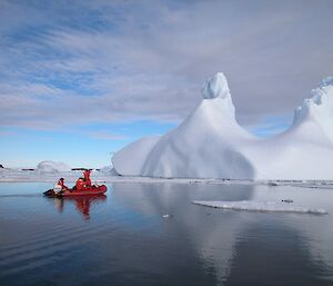 An inflatable rubber boat approaches an iceberg