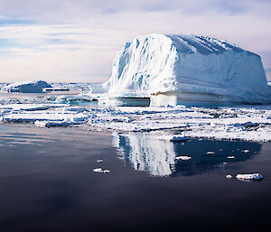 An iceberg illuminated with low angle evening sunlight bringing out various shades of blue