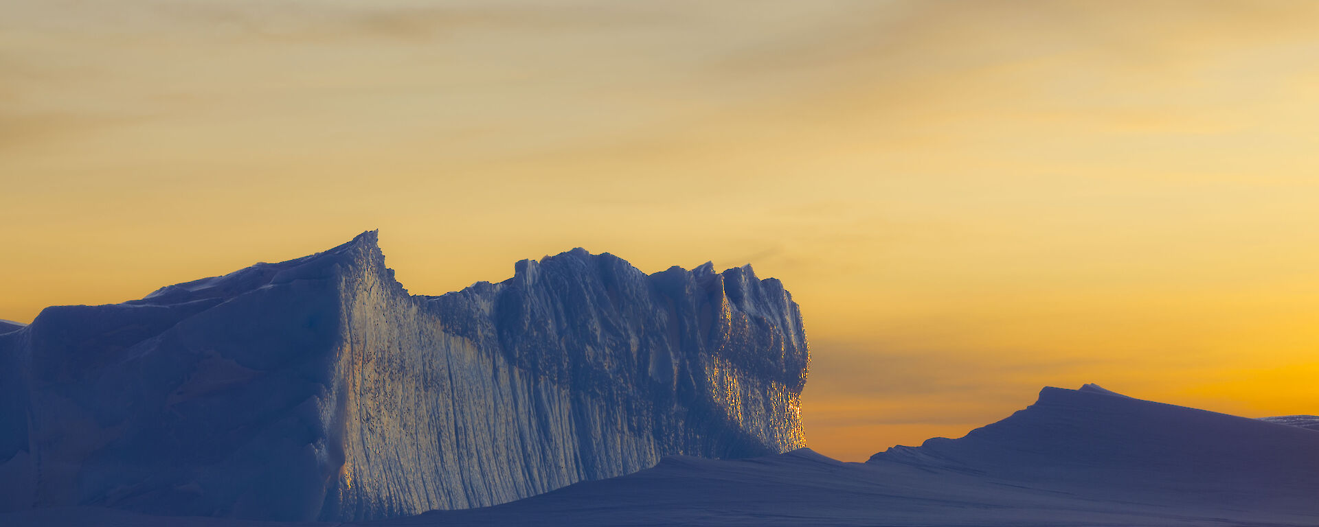 Bright yellow sunset with icebergs in the foreground