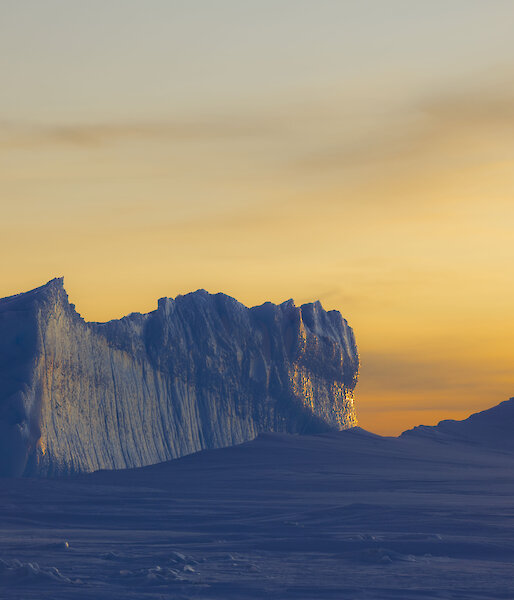 Bright yellow sunset with icebergs in the foreground
