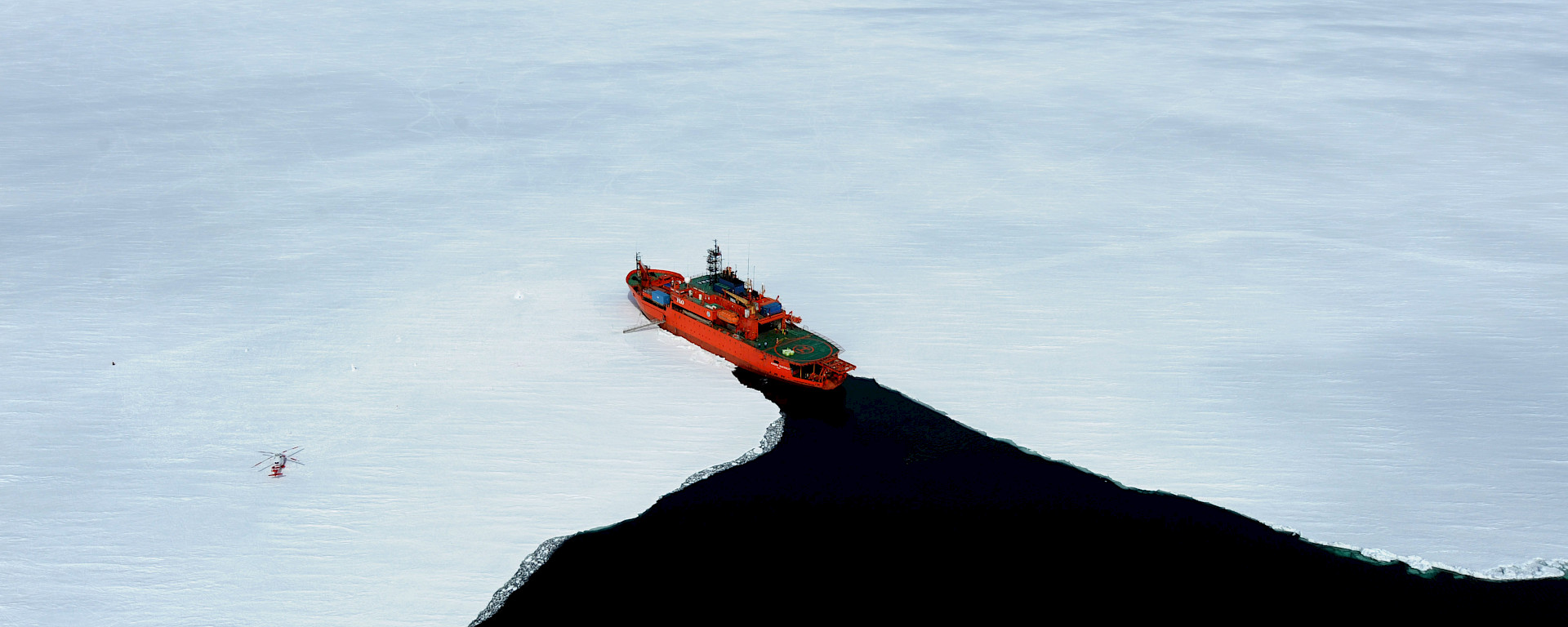 Aerial shot of fast ice at Commonwealth Bay showing Aurora Australis ship entering the ice