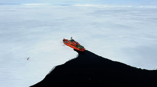 Aerial shot of fast ice at Commonwealth Bay showing Aurora Australis ship entering the ice