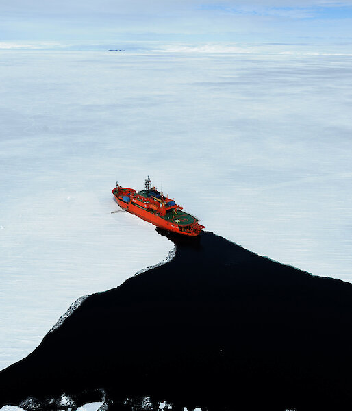 Aerial shot of fast ice at Commonwealth Bay showing Aurora Australis ship entering the ice