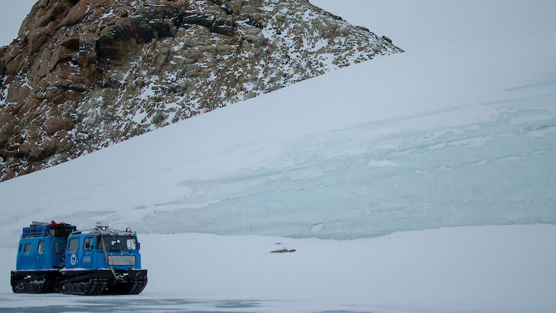 Hägglunds driving past a large ice sheet