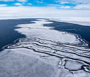 Sea ice viewed from above. The thin ice has been shifted by the ocean to create broken patterns in the surface of the ice.