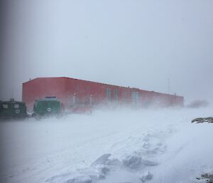 Blizzard with buildings and oversnow vehicles barely visible.