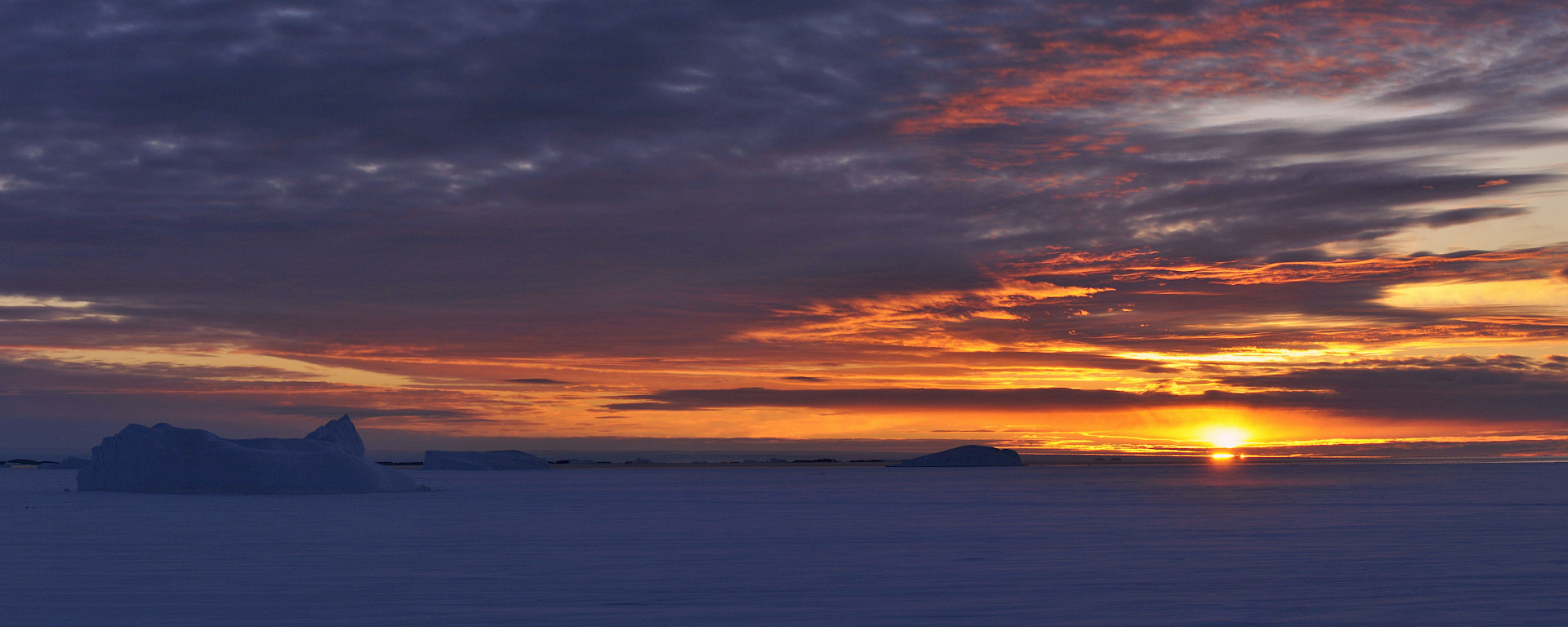 Panorama of sunset over grounded icebergs