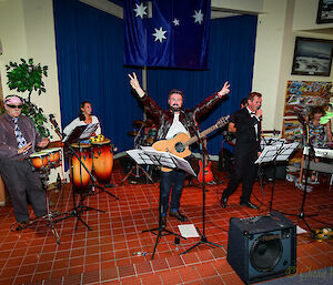 Six expeditioners playing various instruments, including drums, guitar and violin.