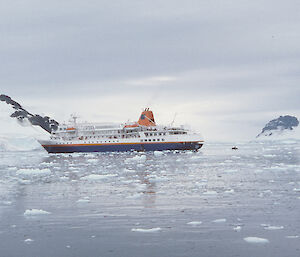 A dated image of a tourist ship in a small bay