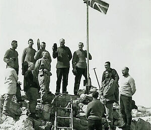 Expeditioners standing on the rocks at the foot of the Union Jack