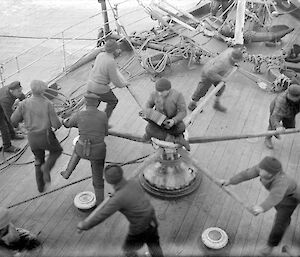 Raising one of the foreyards on the foredeck. The shantyman is providing the working rhythm.