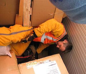 Expeditioner climbing over cargo in hold